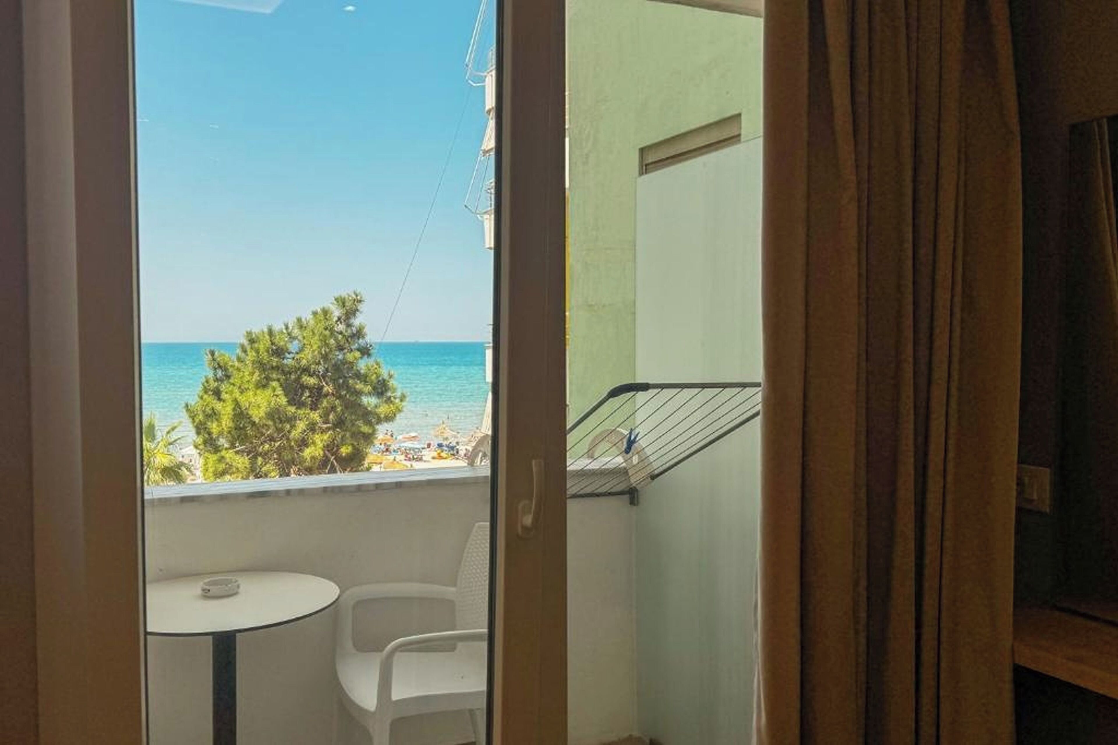 Un balcon avec vue sur la mer, une petite table et une chaise.