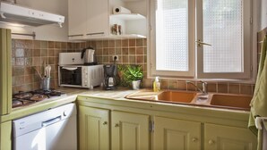 A kitchen with a stove, oven, microwave, and a sink. - In Chjusella - BELGODERE (BELGODERE)