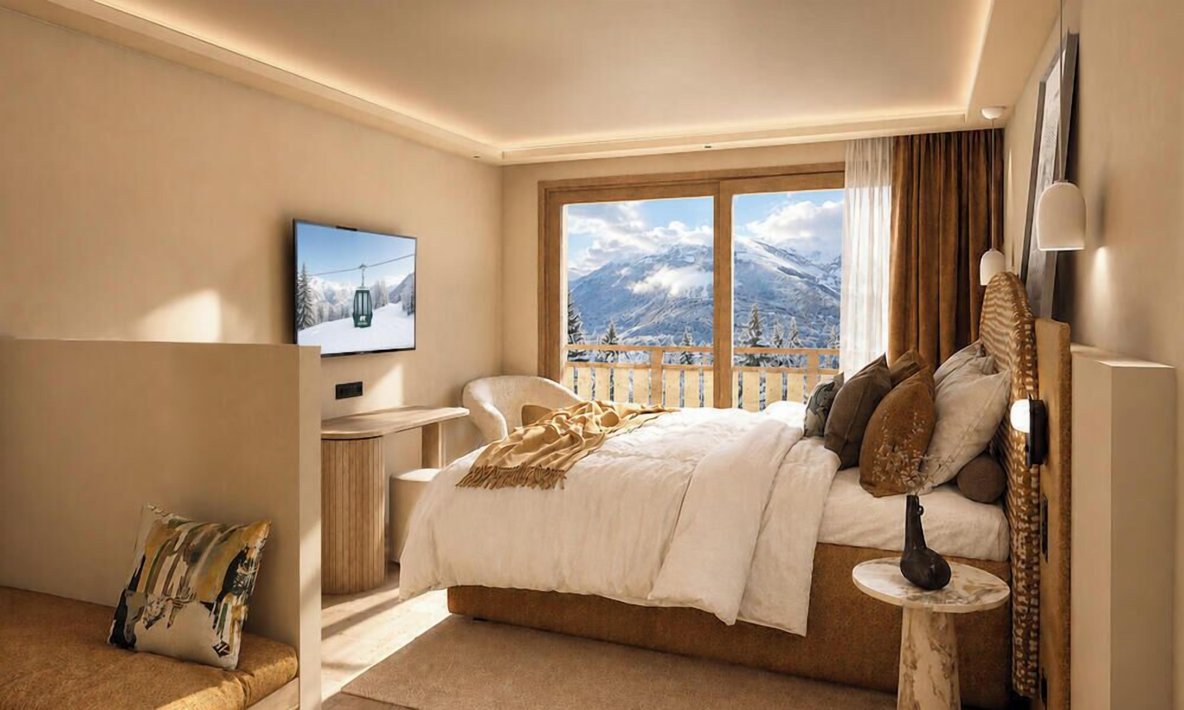 A hotel room with a bed, a television, a window with a mountain view, and a small table with a vase.