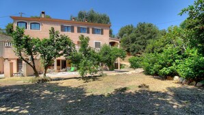 Edifici de dues plantes amb jardí, zona d'estar a l'aire lliure i camí de grava.