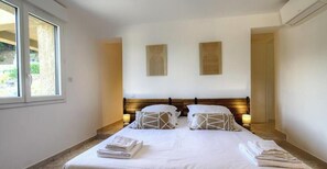 Ein Schlafzimmer mit einem Bett, zwei Wandleuchten und einem Fenster.