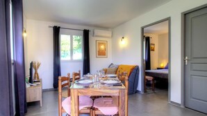 A dining area with a table set for four, a sofa, and a bed in the background. - Ponte - SAN NICOLAO - Gîte (SAN NICOLAO)