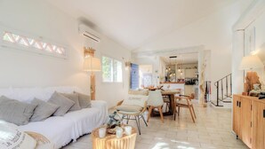 Amplia sala de estar con sofá, mesa de comedor y cocina al fondo.