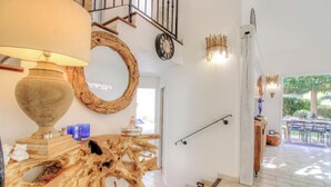 Un interior moderno con una pieza central de madera, un reloj y una escalera.