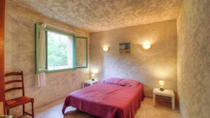 A bedroom with a bed, two bedside tables, a chair, a window with curtains, and two wall-mounted lights. - The strawberry tree - SAN GAVINO DI CARBINI (SAN GAVINO DI CARBINI)