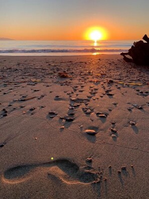 Ein Strand mit Fußspuren und Felsen.