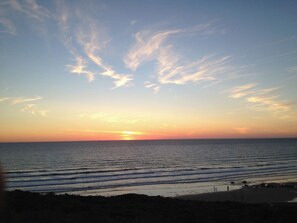 A sunset over the ocean with a clear sky. - Lowenna (Newquay)