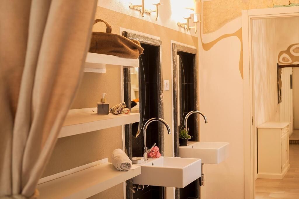 Un baño con dos lavamanos, un perchero y un espejo.
