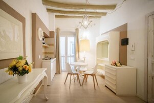 Una stanza con un tavolo da pranzo, sedie, un lampadario, una cassettiera bianca e uno specchio.