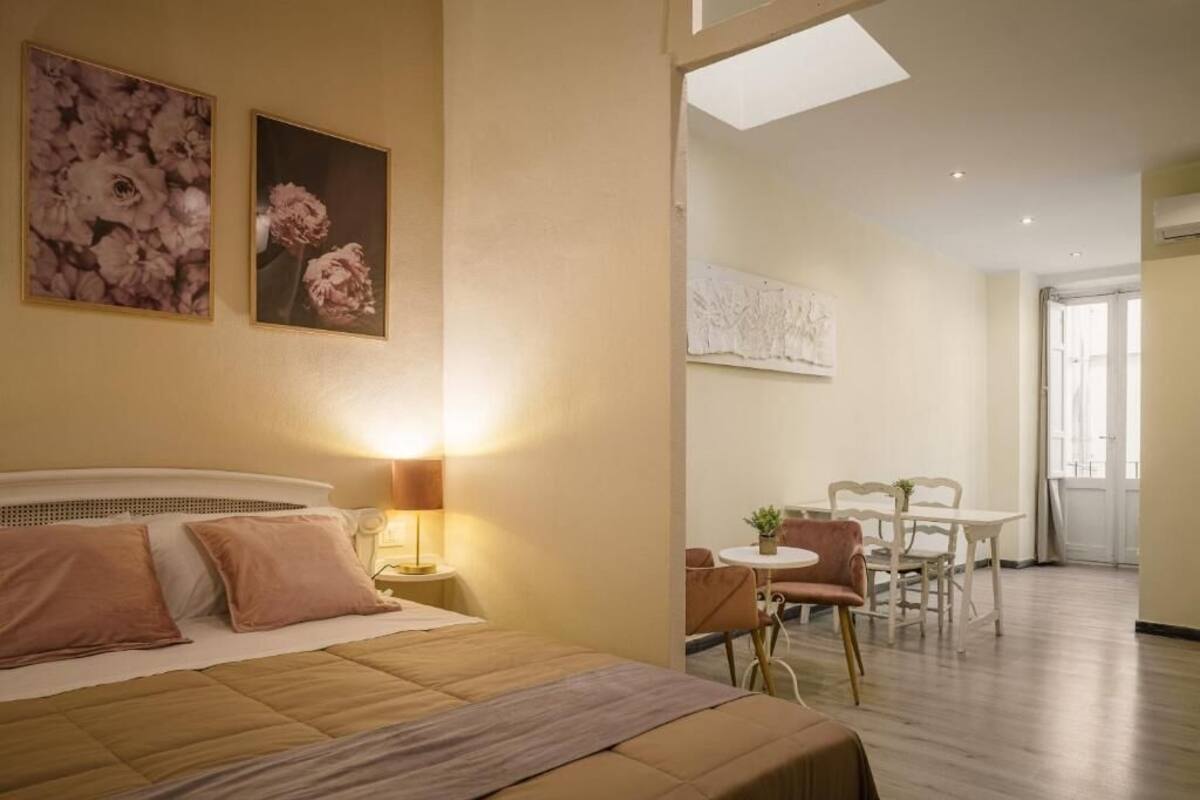 Una habitación de hotel con cama, escritorio, silla y mesa de comedor.