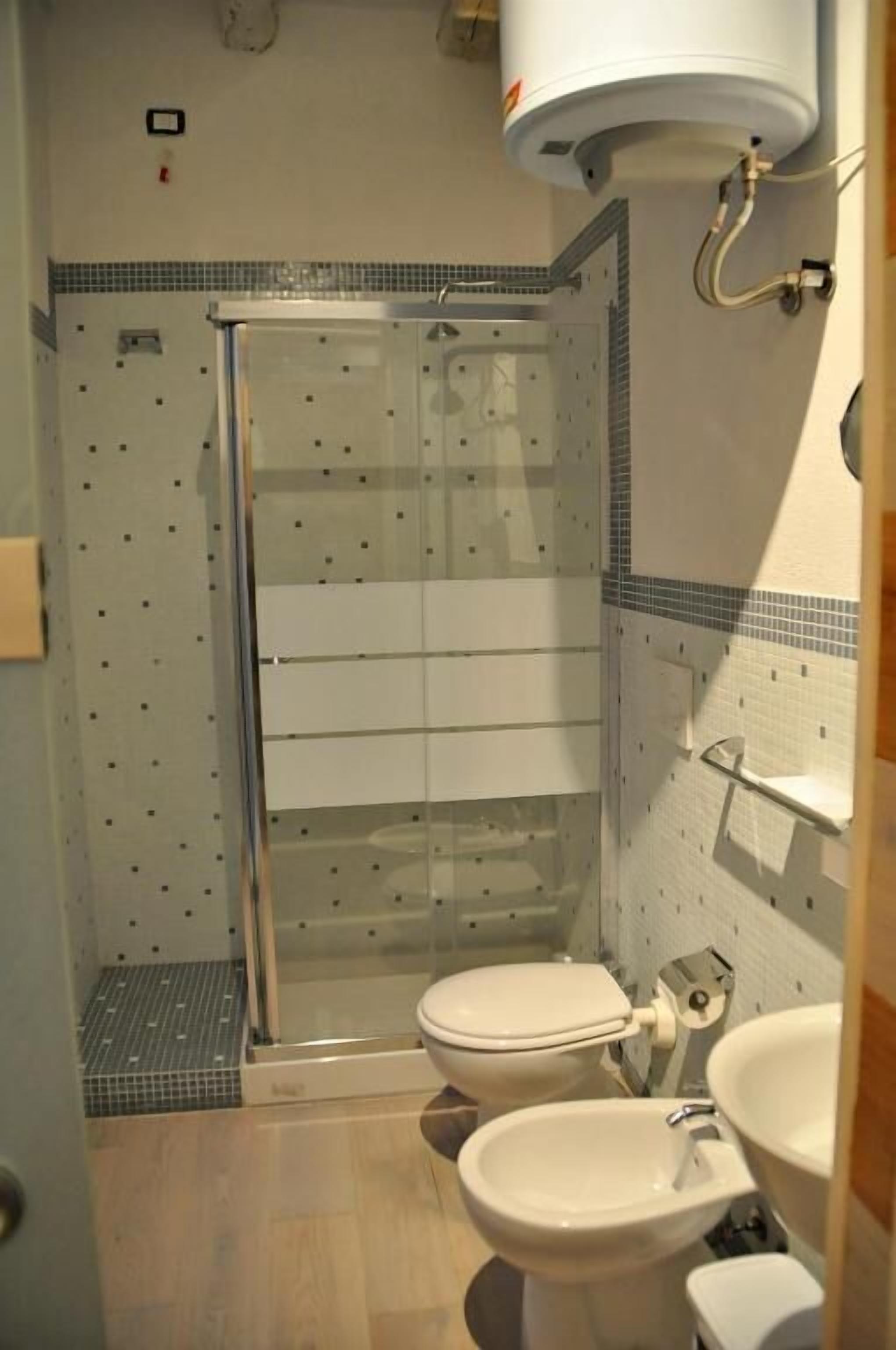 A bathroom with a shower, toilet, and sink.
