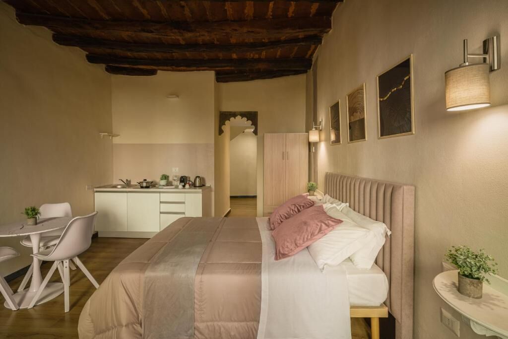 Une chambre à coucher avec un lit, une table de chevet et un petit bureau avec une chaise.