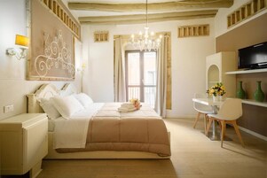 Una camera da letto con un letto, una scrivania, una sedia, una televisione e un lampadario.