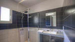 A modern bathroom with a glass shower enclosure, a sink, and a mirror. - L'Ogliastru - SOLLACARO (SOLLACARO)