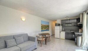 Ein kompakter Wohnbereich mit Sofa, Esstisch und Küchenzeile.