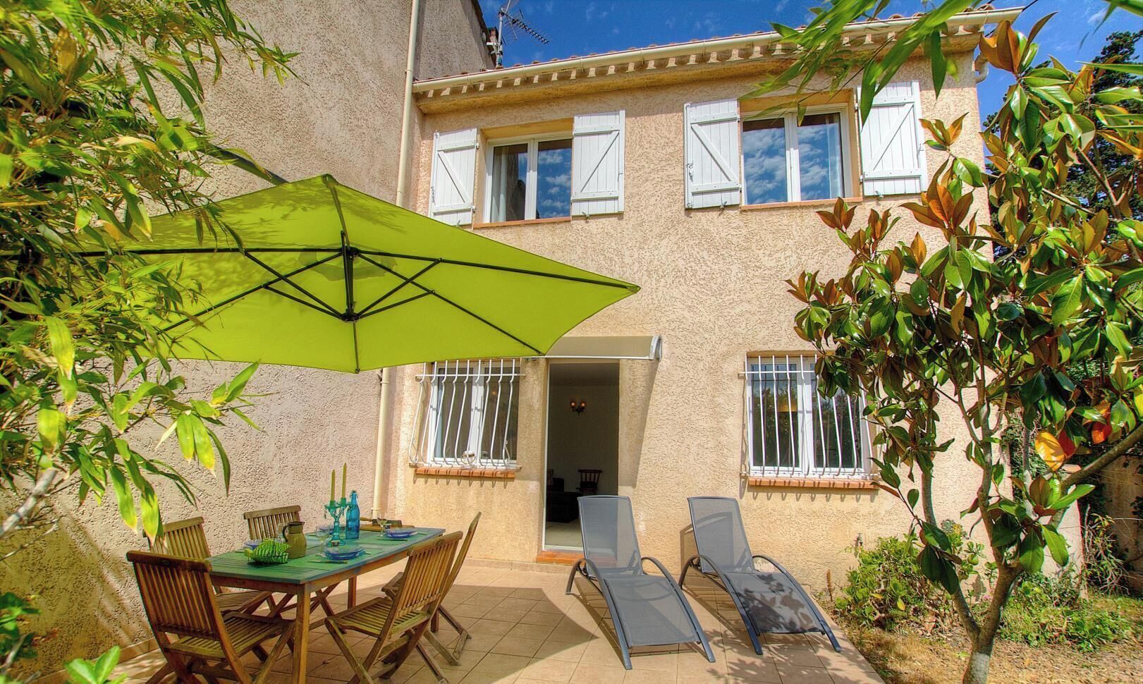 A patio with a table, chairs, and an umbrella.