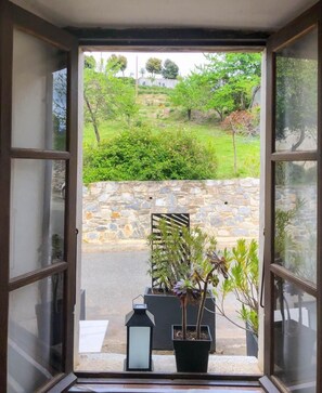 An open door with a view of a stone wall, a potted plant, and a lantern. - The Milky Way - ERBAJOLO (ERBAJOLO)