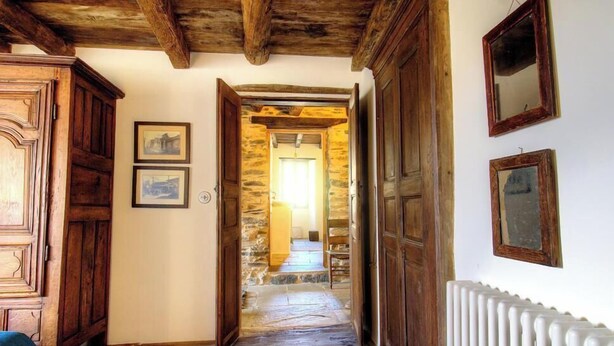 A hallway with wooden doors, stone walls, and a radiator. - Casa Formosa - PENTA DI CASINCA (PENTA DI CASINCA)