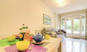 A dining area with a table set for a meal, a sofa, and a window with a view. - Fontanaccia - PERI PLAIN (PLAINE DE PERI)