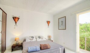 A bedroom with a bed, two bedside tables, a nightstand, a window with a view of greenery, and wall-mounted lamps. - Fontanaccia - PERI PLAIN (PLAINE DE PERI)