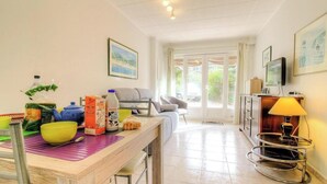 A room with a dining table, chairs, a sofa, a television, and a lamp. - Fontanaccia - PERI PLAIN (PLAINE DE PERI)