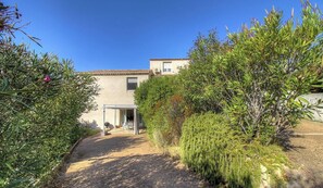A house with a covered patio, a gravel path, and dense greenery. - Fontanaccia - PERI PLAIN (PLAINE DE PERI)