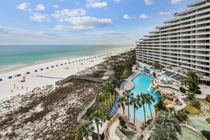 Ein Resort mit Strand, Schwimmbad und einem großen Gebäude.