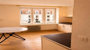 Een kleine keuken met een raam, een eettafel en een aanrecht.