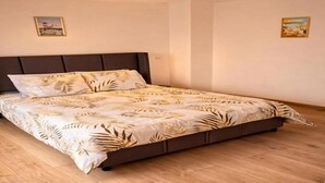 Een slaapkamer met een bed, een hoofdbord en twee foto’s aan de muur.