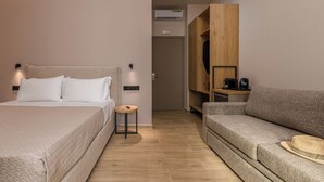 A modern hotel room with a bed, a sofa, a small round table, and a wardrobe. - Anese Vacation Feelings (Paliouri)