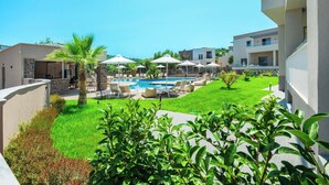 A resort with a swimming pool, lounge chairs, and palm trees. - Anese Vacation Feelings (Paliouri)