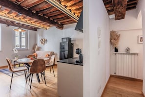 Una cucina moderna con forno a microonde integrato, frigorifero e piano di lavoro nero.