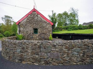 A stone building with a red roof, a small window, and a sign that reads 'CIS DA MARA'. - House of the Sea - Camp (Kilgobban)