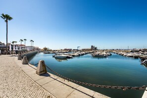A marina with boats docked, a paved walkway, and palm trees. - Casa Rizzo in Faro With 2 Bedrooms and 2 Bathrooms (Faro)