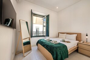 A bedroom with a bed, bedside table, nightstand, and a window with shutters. - Casa Rizzo in Faro With 2 Bedrooms and 2 Bathrooms (Faro)