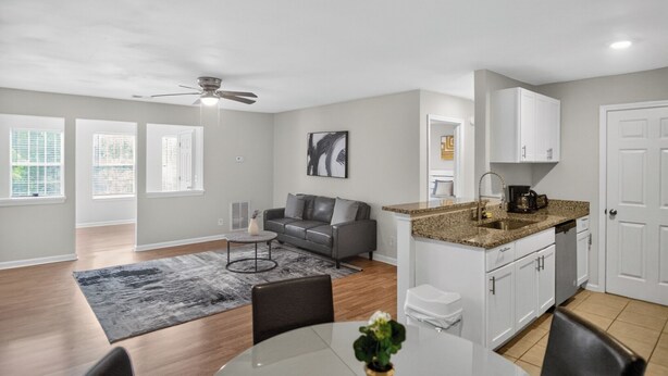 A modern apartment with a dining area, kitchen, and living room.