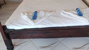 Una cama con dosel, dos almohadas y dos toallas.