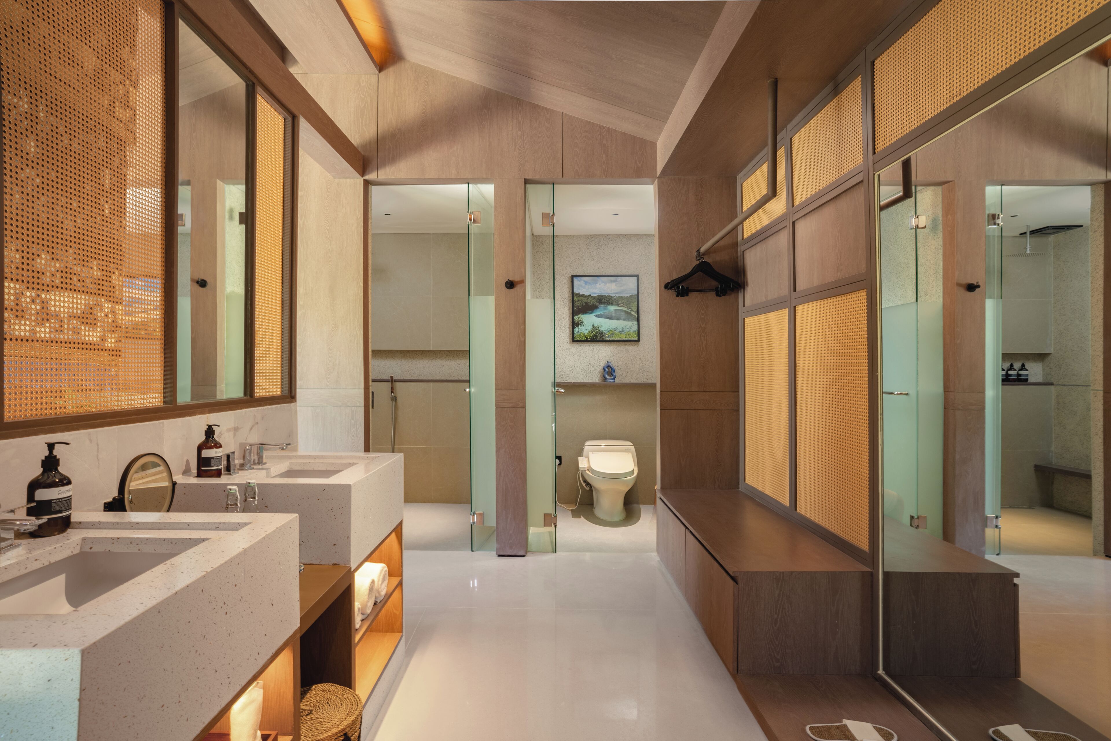A modern bathroom with two sinks, a toilet, and a shower area.
