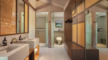 A modern bathroom with two sinks, a toilet, and a shower area.