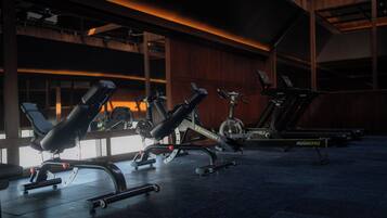 Uma academia com diversos equipamentos de ginástica, incluindo esteiras e máquinas de musculação.