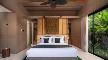 A modern bedroom with a large bed, a ceiling fan, and a view of greenery outside.