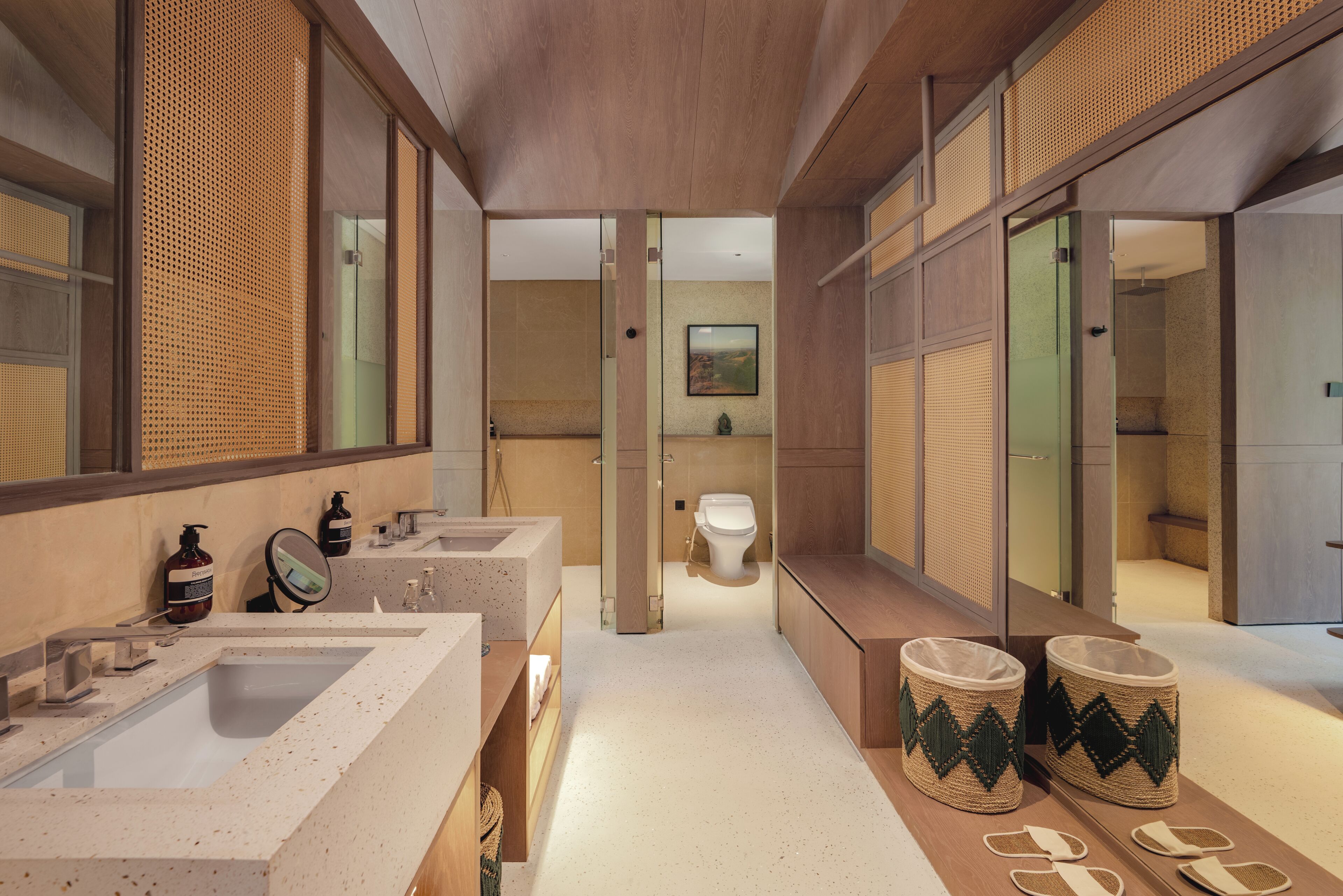 Un baño moderno con dos lavamanos, inodoro y zona de ducha.