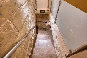 A staircase with stone walls, metal handrails, and a glass panel on the right. - Beautiful traditional house in Rabat AMUS1-1 (Rabat)