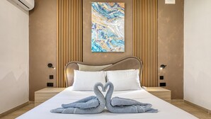 A hotel room with a bed, two bedside lamps, a wall-mounted air conditioner, and a painting. - Beautiful traditional house in Rabat AMUS1-1 (Rabat)