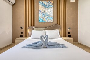 A hotel room with a bed, two bedside lamps, a wall-mounted air conditioner, and a painting. - Beautiful traditional house in Rabat AMUS1-1 (Rabat)