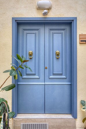 A blue door with two brass knockers, a small window above, and a plant to the left. - Beautiful traditional house in Rabat AMUS1-1 (Rabat)
