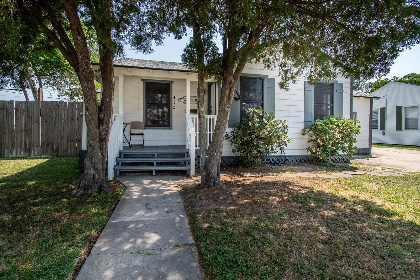A single-story house with a front porch, a small set of steps leading to the door, and a mailbox.