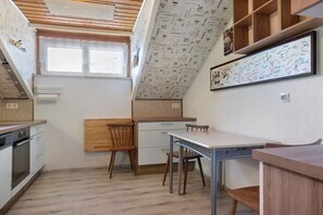 A compact kitchen with a wooden ceiling, a window, and a wall with a coffee-themed mural. - Apartment Ri-Wo with Shared Terrace, Garden, and Wi-Fi (Malta)