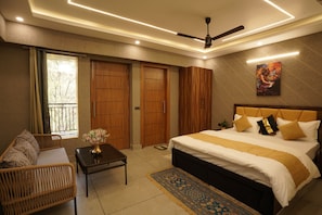 Un dormitorio con cama, sofá, mesa, ventilador de techo y ventana.
