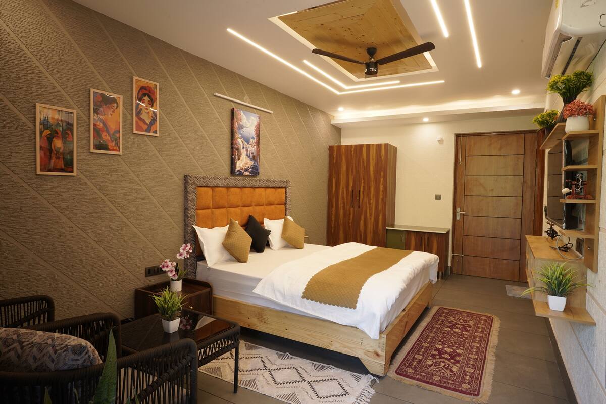 A bedroom with a bed, nightstands, a chair, a TV, a wardrobe, and a ceiling fan.